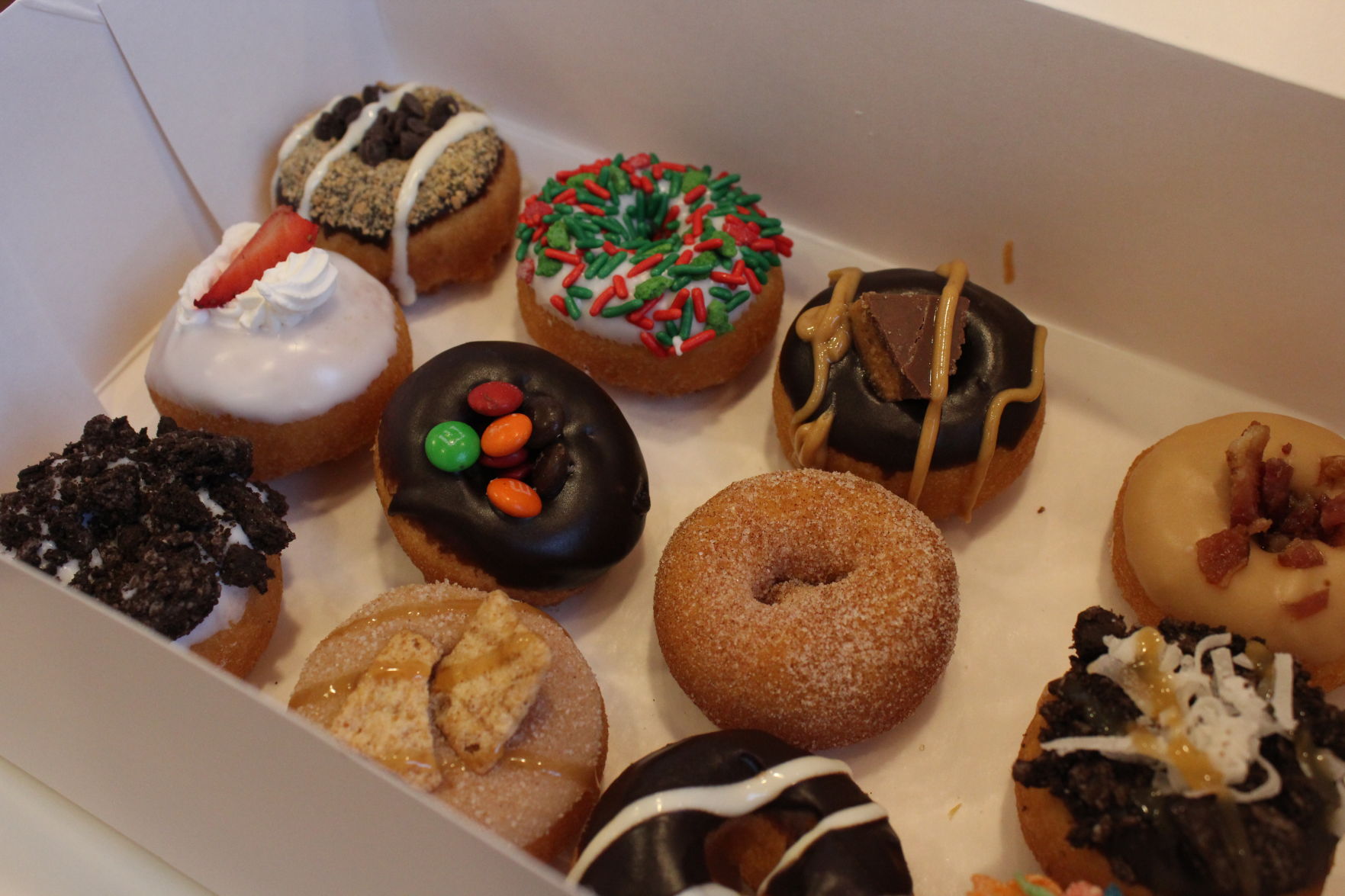 A box with 12 different flavors of doughnuts sits on a counter in the Humble Donut Company store